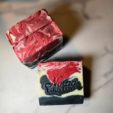 Marbled red, black, and white Noraa Body Love soap bars with a brand name on a neutral background